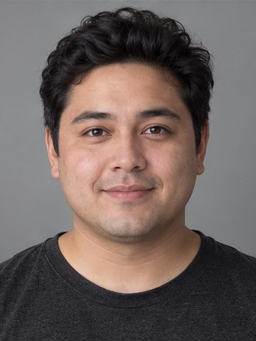 A fictional creator with short dark hair and a charcoal shirt.